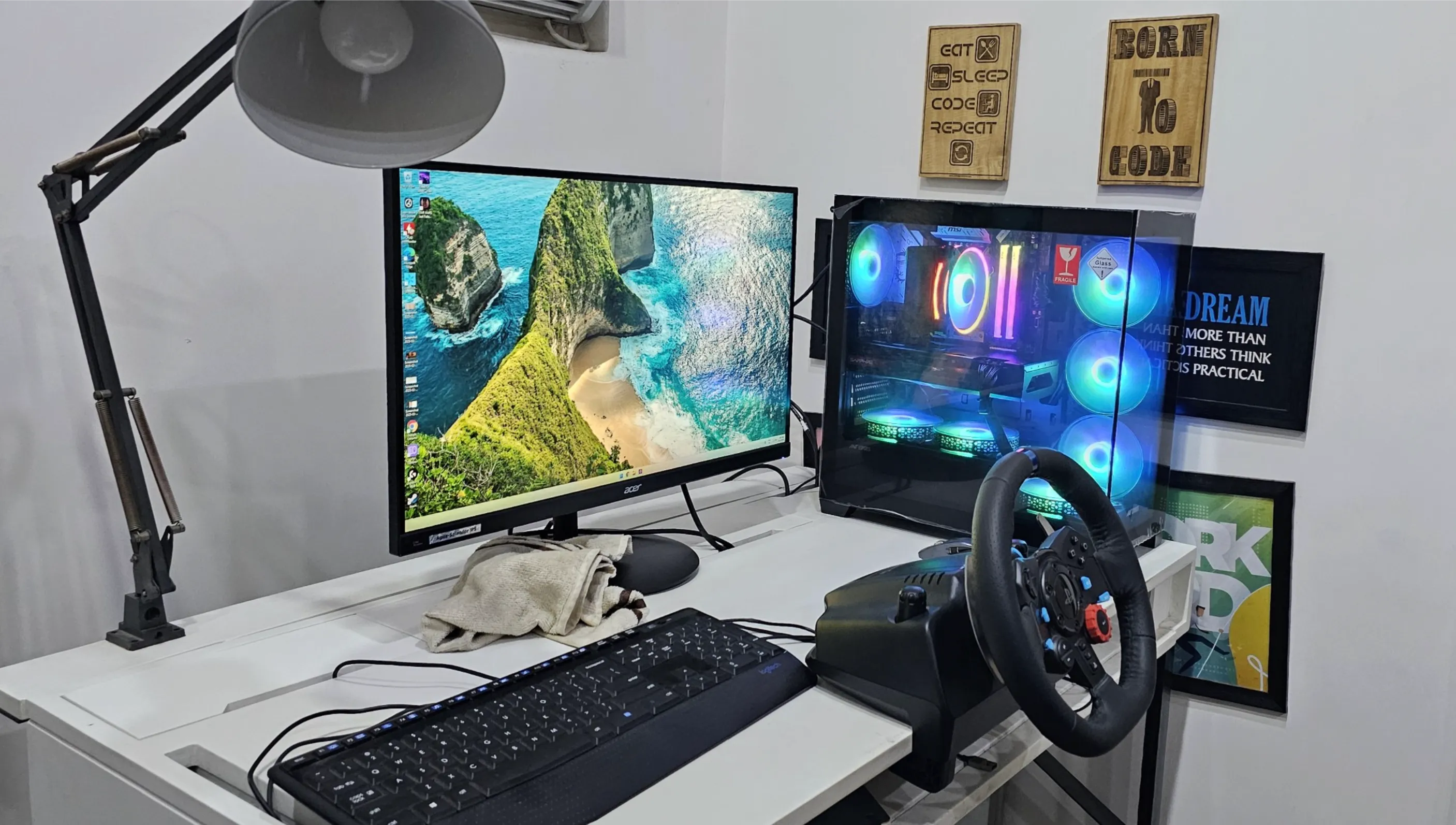 My Windows gaming PC setup with the Acer monitor, RGB desktop tower, keyboard, and racing wheel